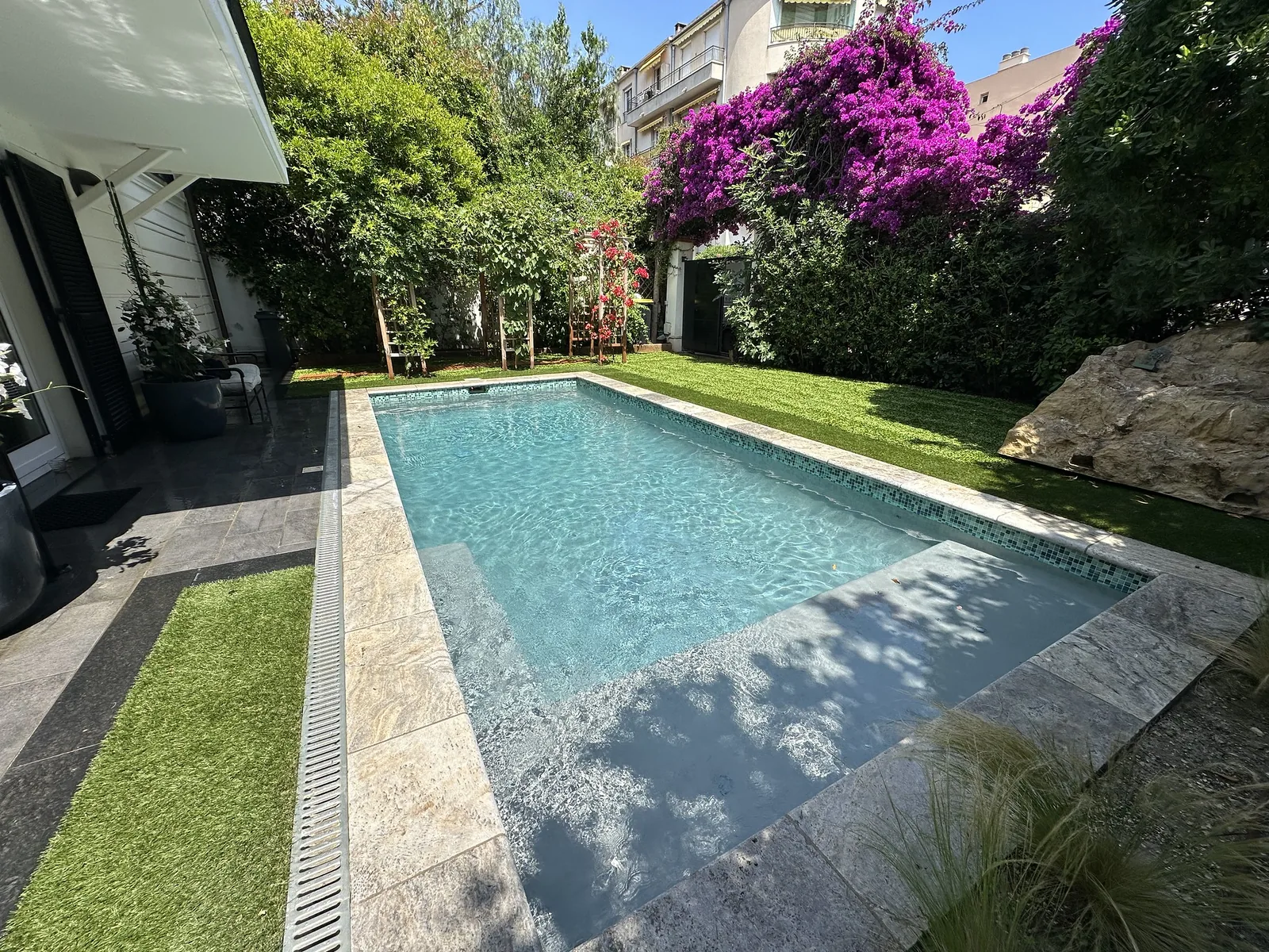 Pool surrounded by lawn and flowering greenery
