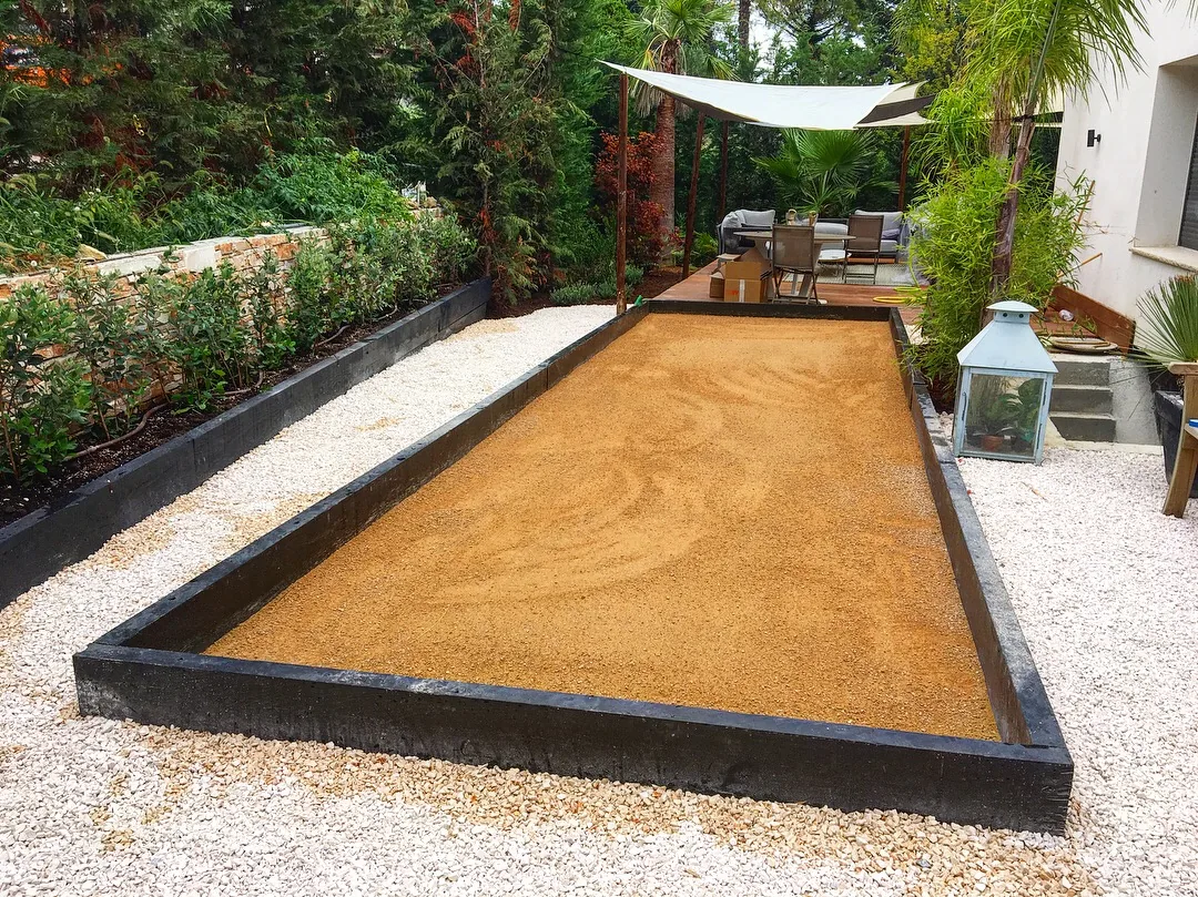 Terrain de pétanque bordé de plantations